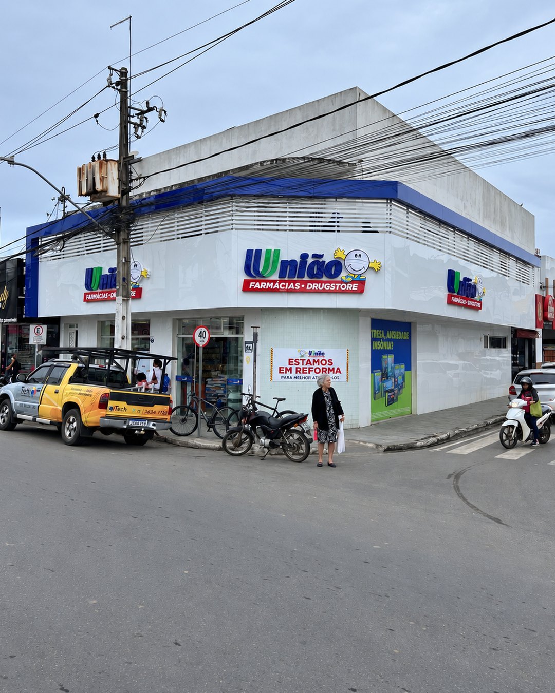 Fachada de esquina da União Farmácias em ACM branco e azul, com letreiros, feita pela Tech