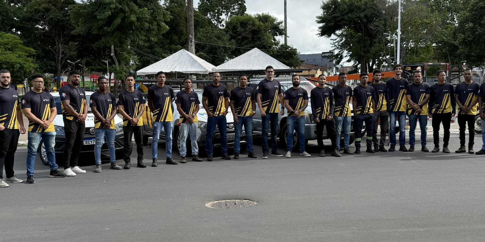 Equipe da Tech uniformizada em frente aos veículos da empresa